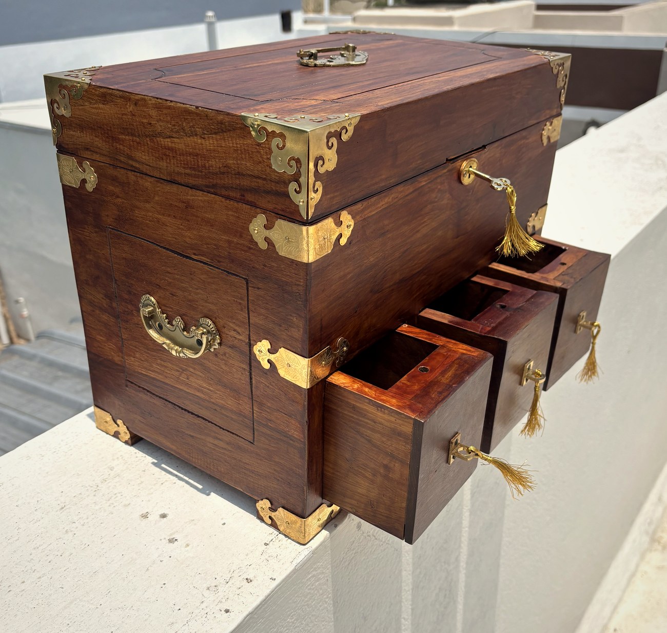 Side view with the drawers pulled out and brass carry handle