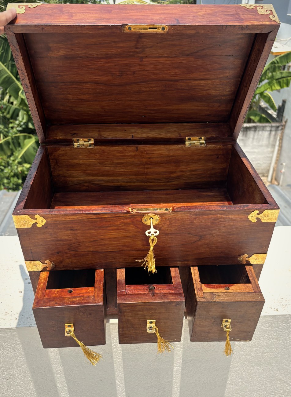 The chest open, showing the lidded well and three drawers