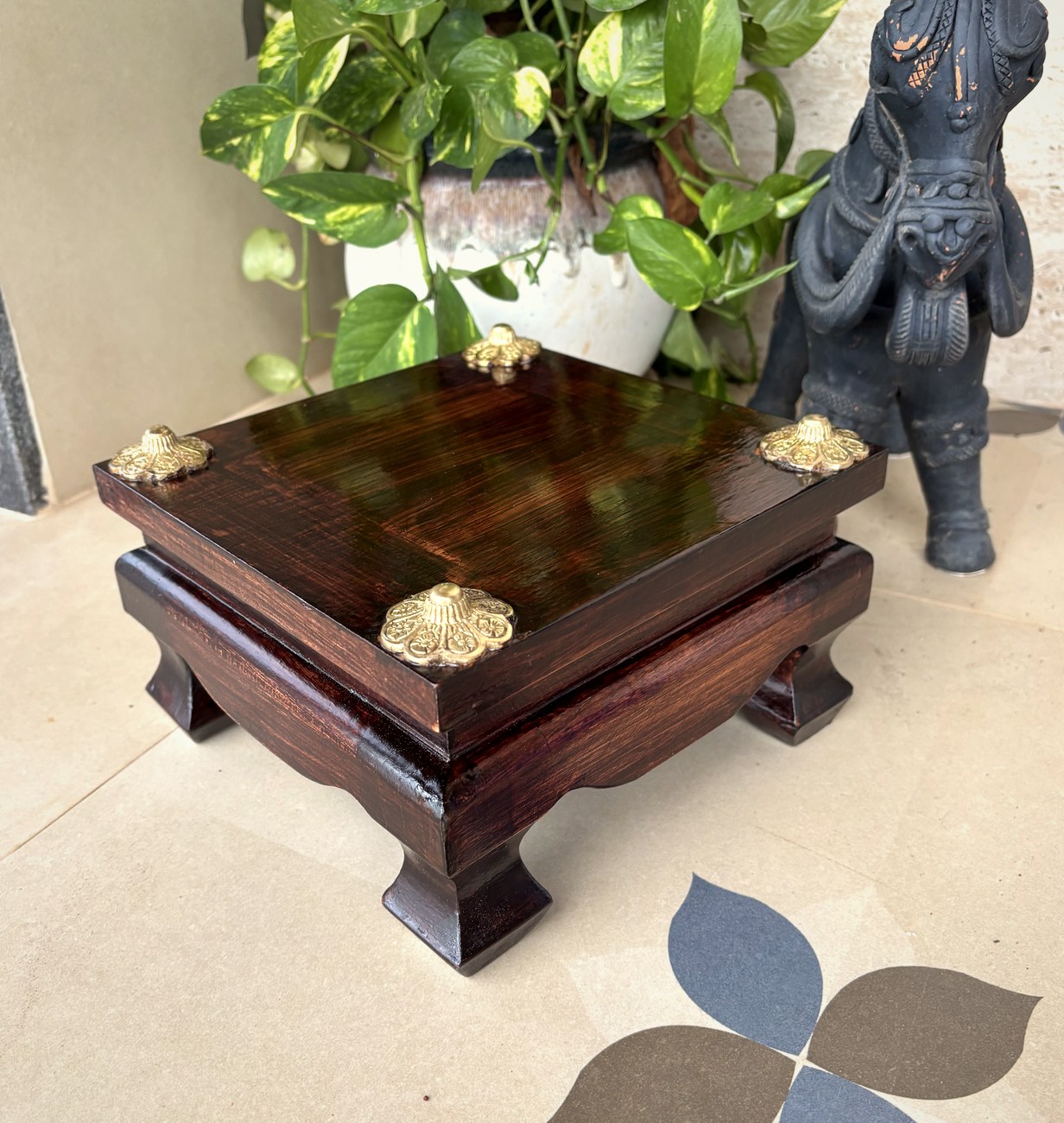 Dark teak pooja chowki with cast brass corner caps and shaped feet