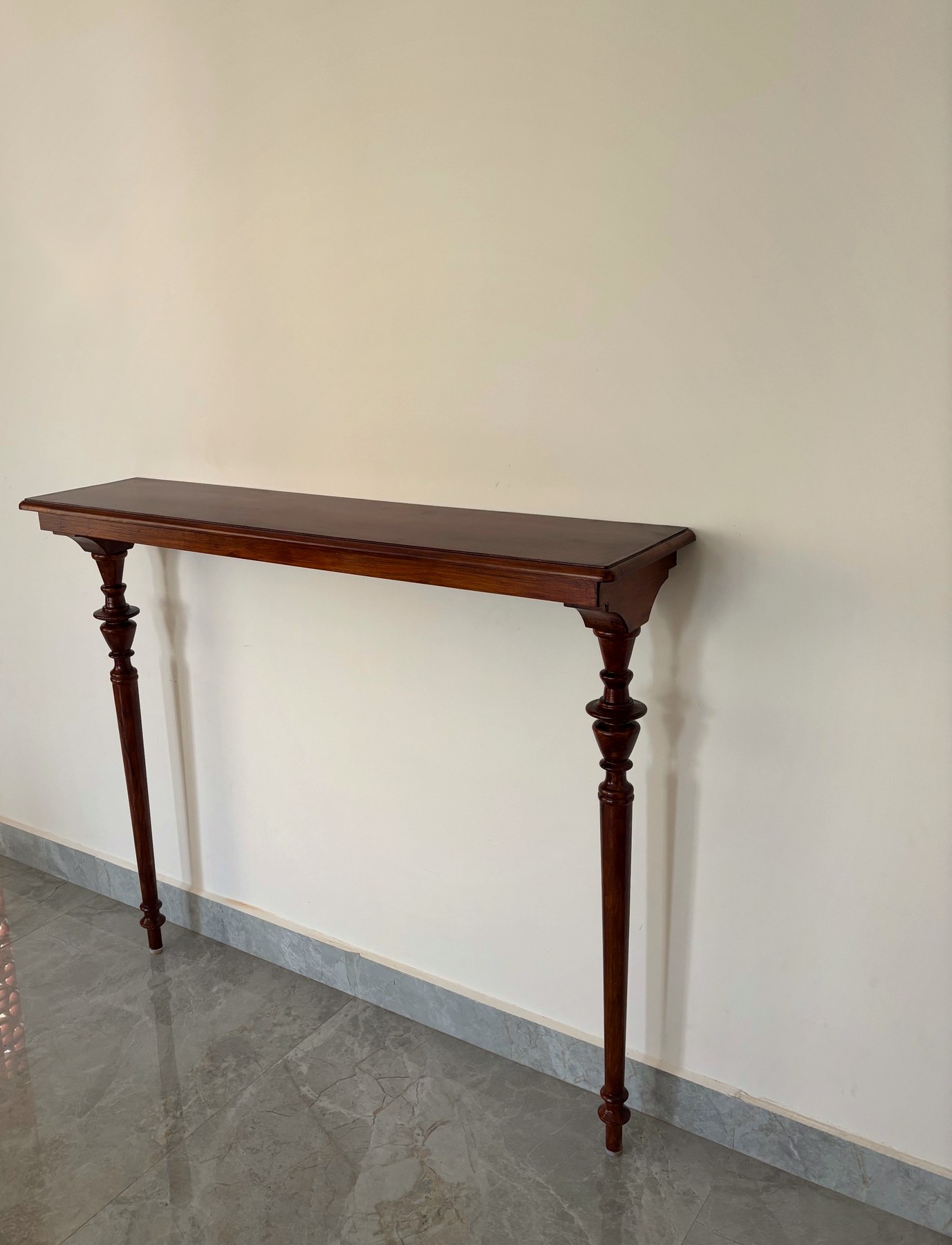 Classic teak foyer table with turned legs and carved corbels