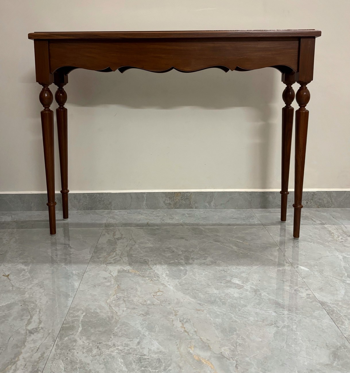 Four-leg teak foyer table with a scalloped apron
