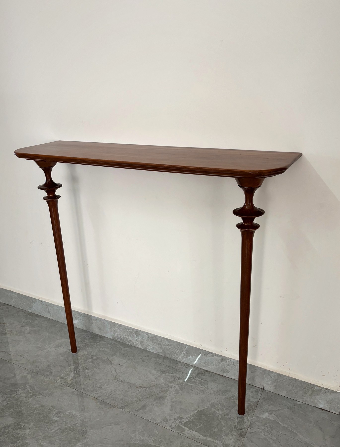 Modern two-leg teak foyer table with a rounded top