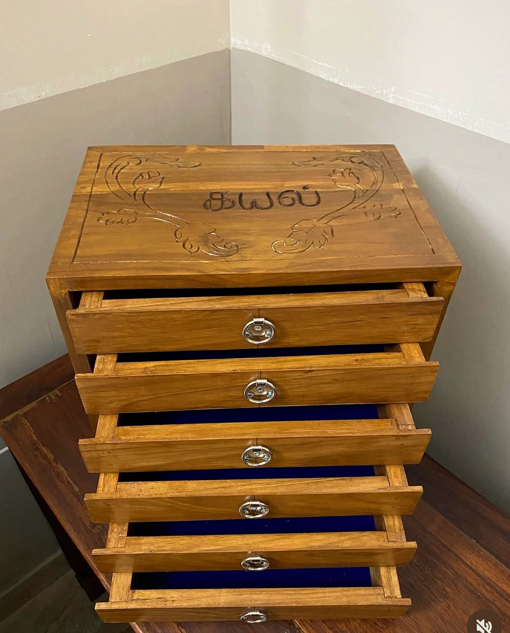 Teak jewellery chest with six drawers and a carved lid