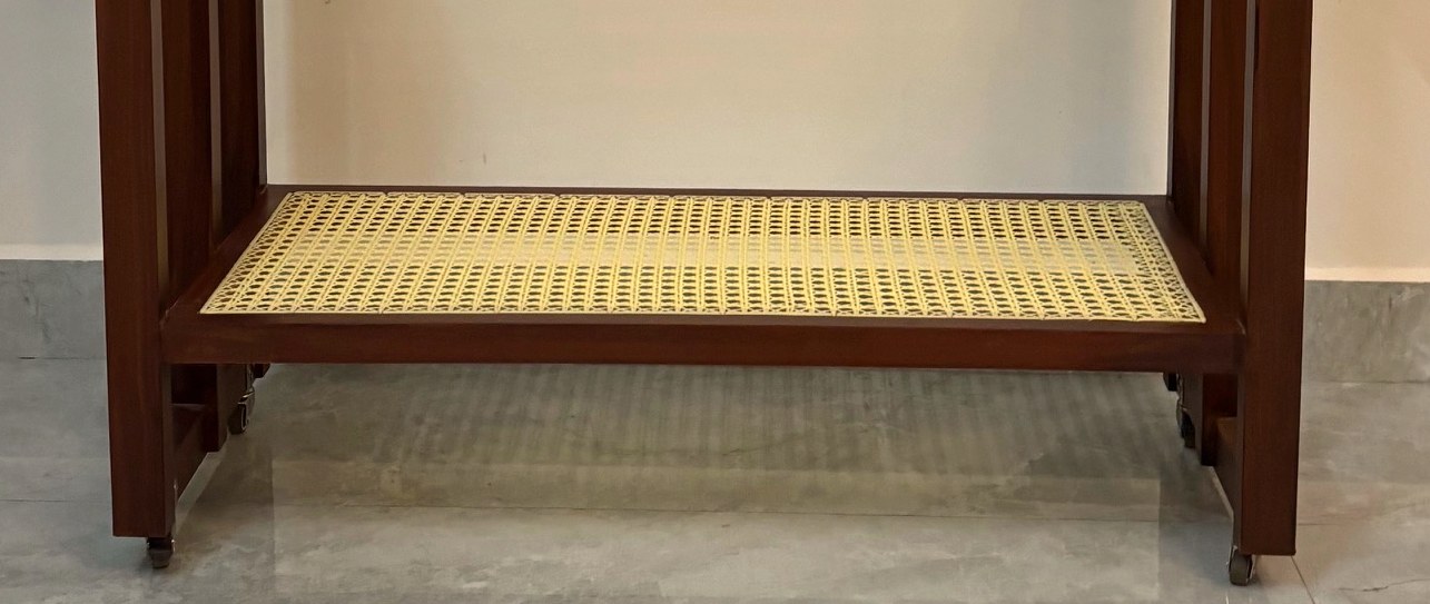 Close-up of the hand-woven cane shelf and its teak frame