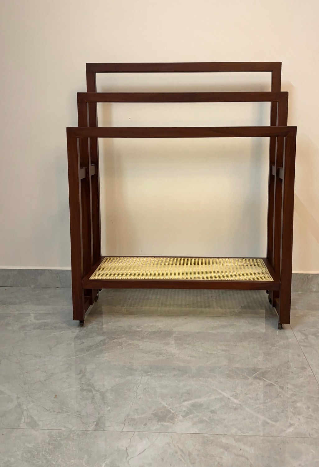 Three-rail teak towel stand with a woven cane shelf