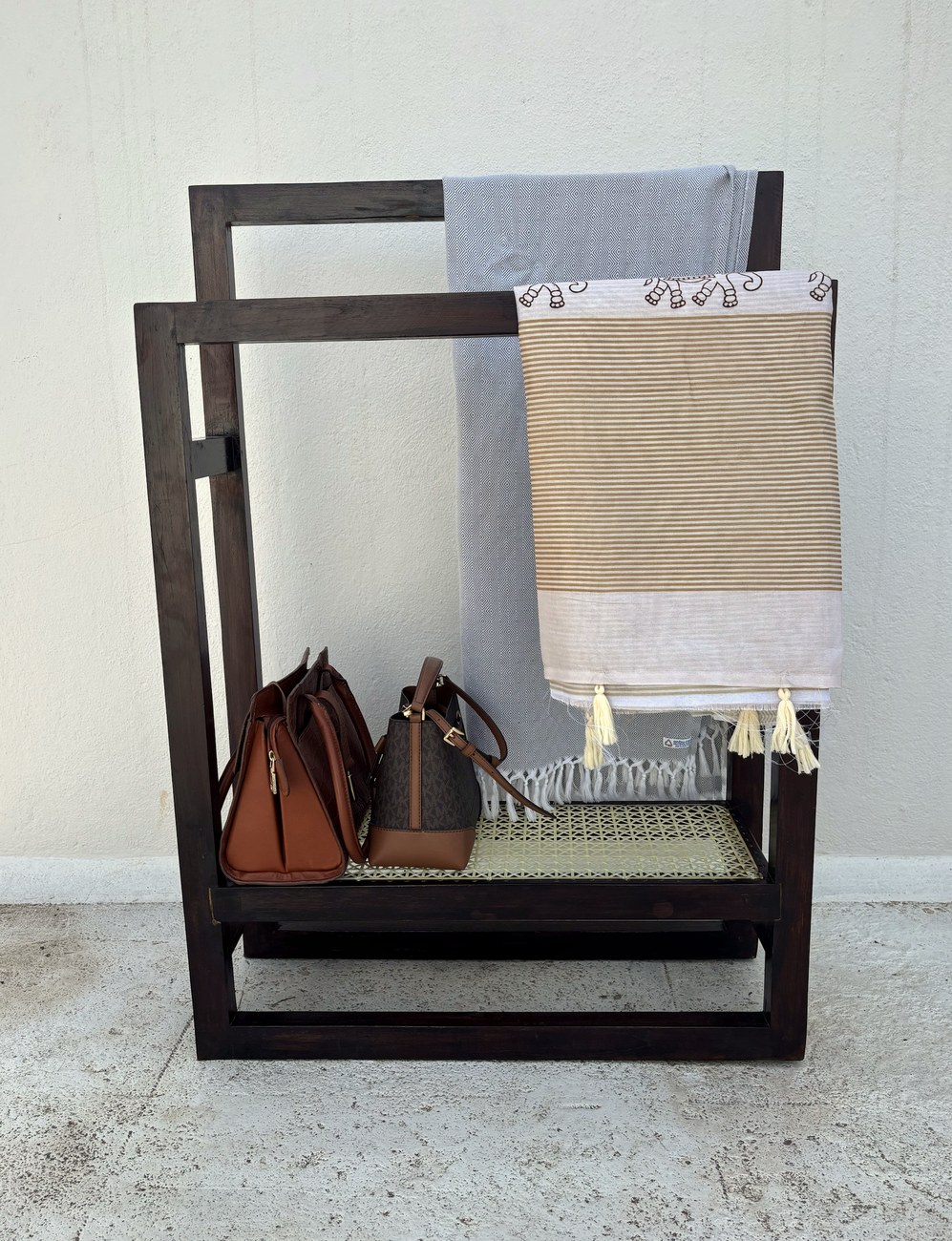 Towel stand in use with towels and bags