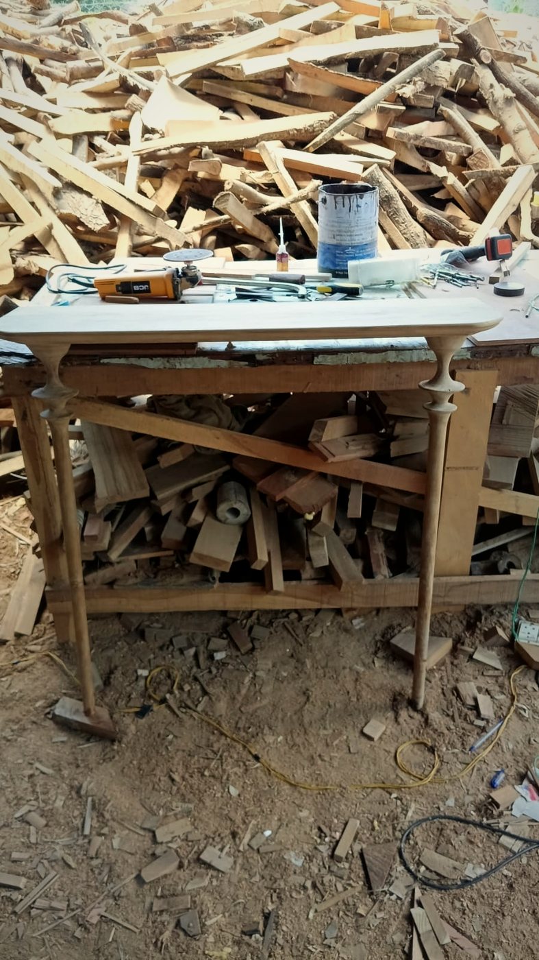 An unfinished teak console table on the workbench